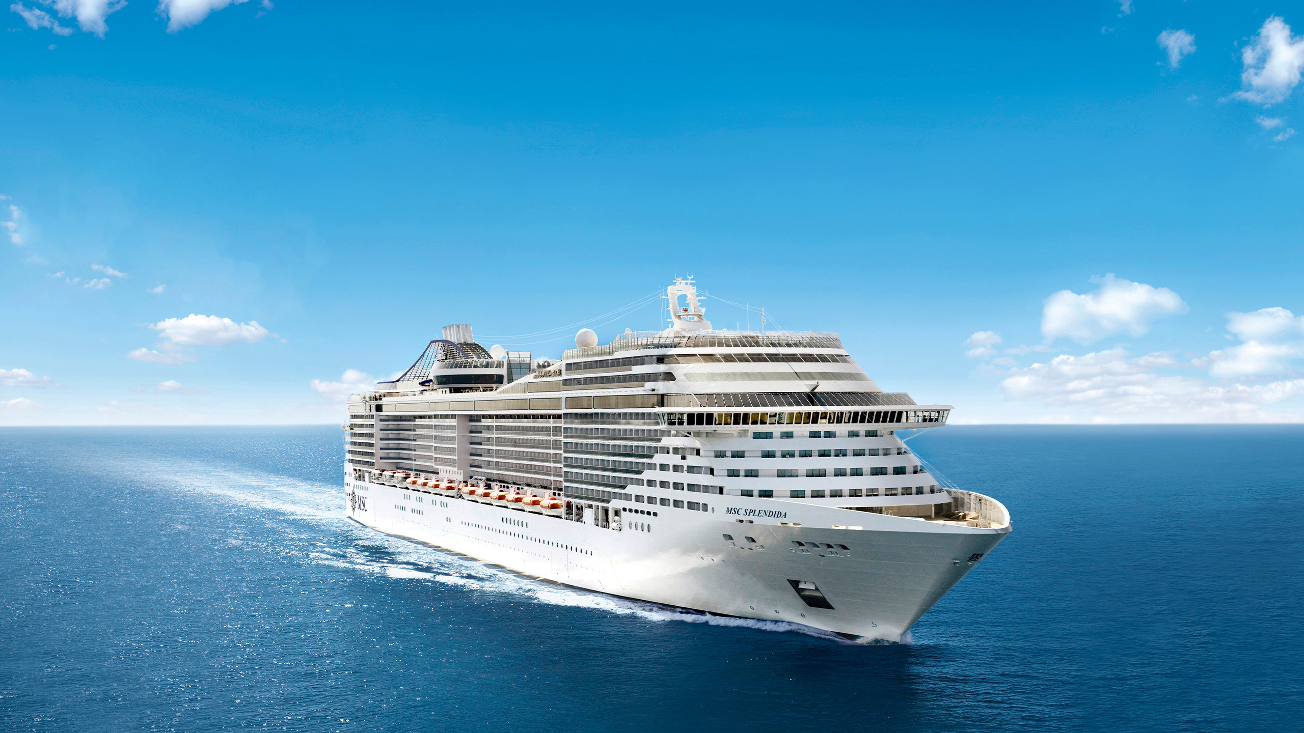 Cruise ship sailing on open ocean at sunrise